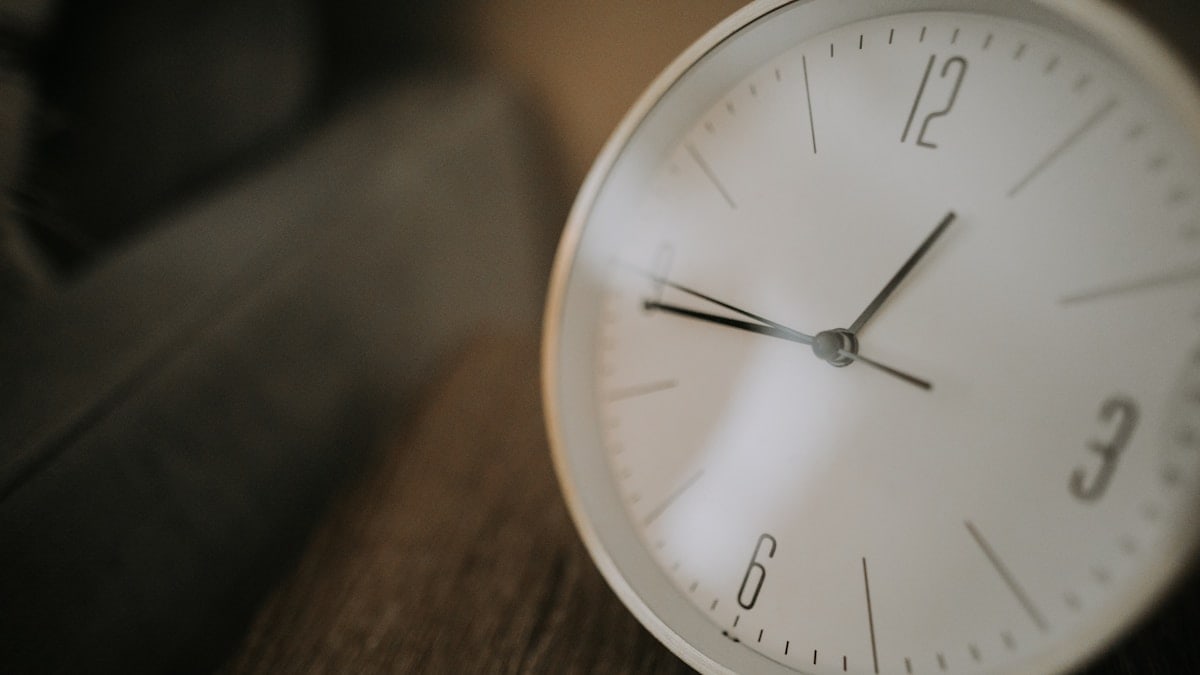 white analog wall clock with white wooden frame